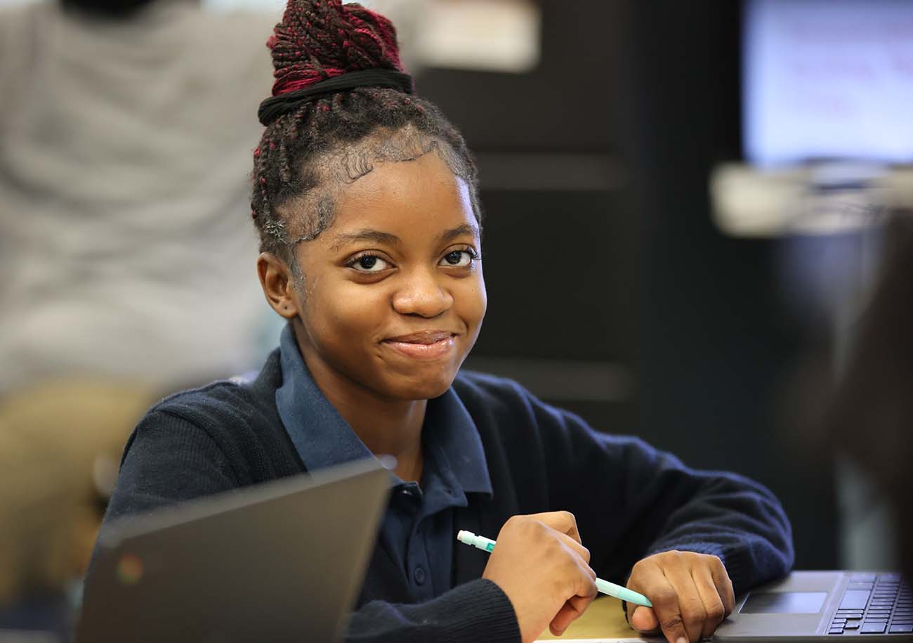 Student working on a notebook in a classroom.